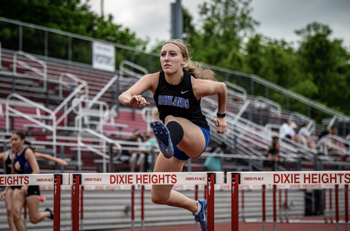 Junior Shelby Shields jumps over the hurdles at the Dixie track meet.